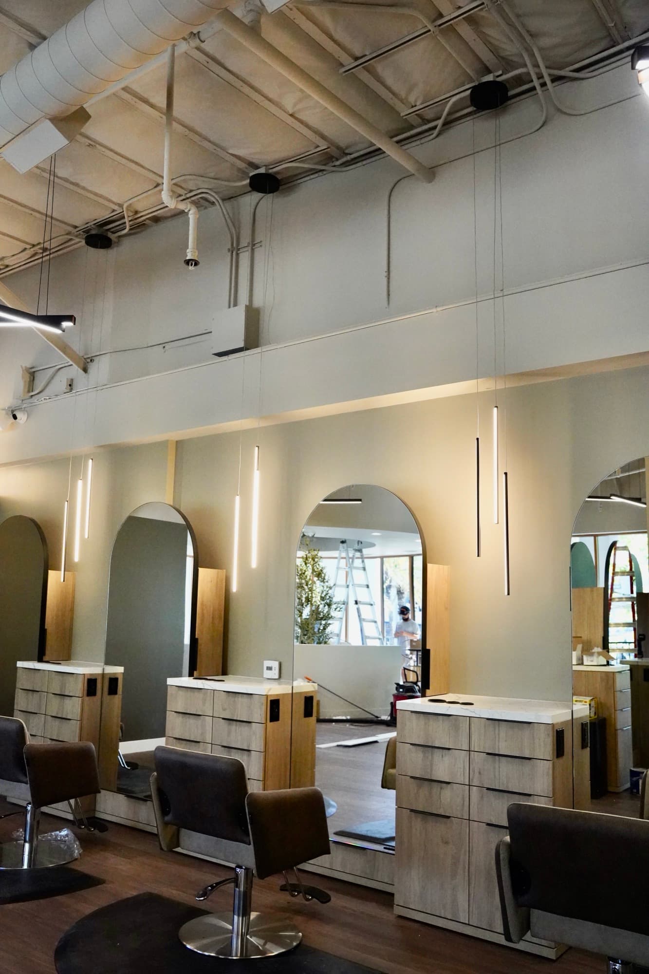Completed salon styling stations under custom pendant lighting